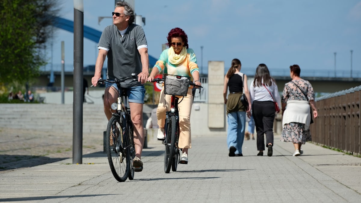 Active couple enjoying a bike ride on a sunny day in the city.
